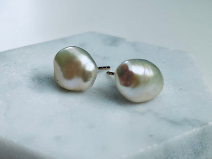Pair of pearl earrings on a hexagonal stone block