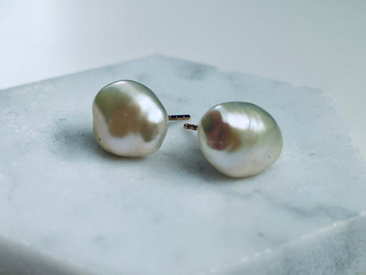 Pair of pearl earrings on a hexagonal stone block