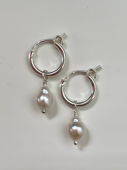 A pair of white baroque pearl earrings with gold vermeil or sterling silver hoops, displayed against a white background.